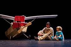 Man and boy sitting by airplane