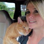 Woman in car with orange cat