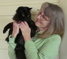 woman holding black cat