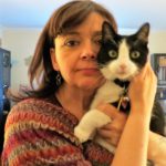 Woman holding black & white cat