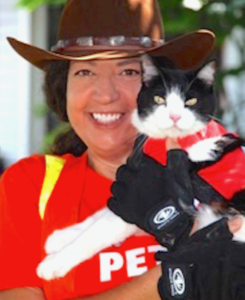 woman in cowboy hat holding black cat