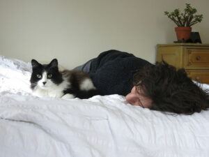 Black & white cat in bed with person