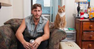 cat sitting next to man