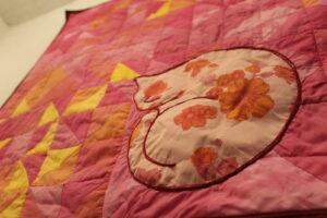 flowered cat on pink quilt