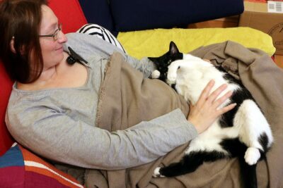 Woman resting with cat on her lap