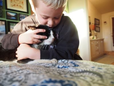 Young boy loving black cat