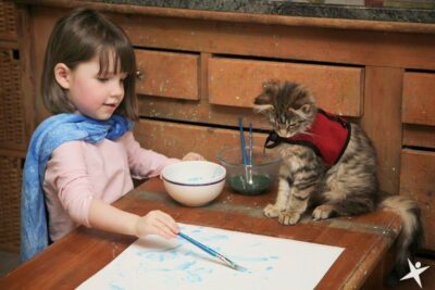 Cat watching child paint