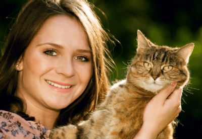 young woman holding tabby cat